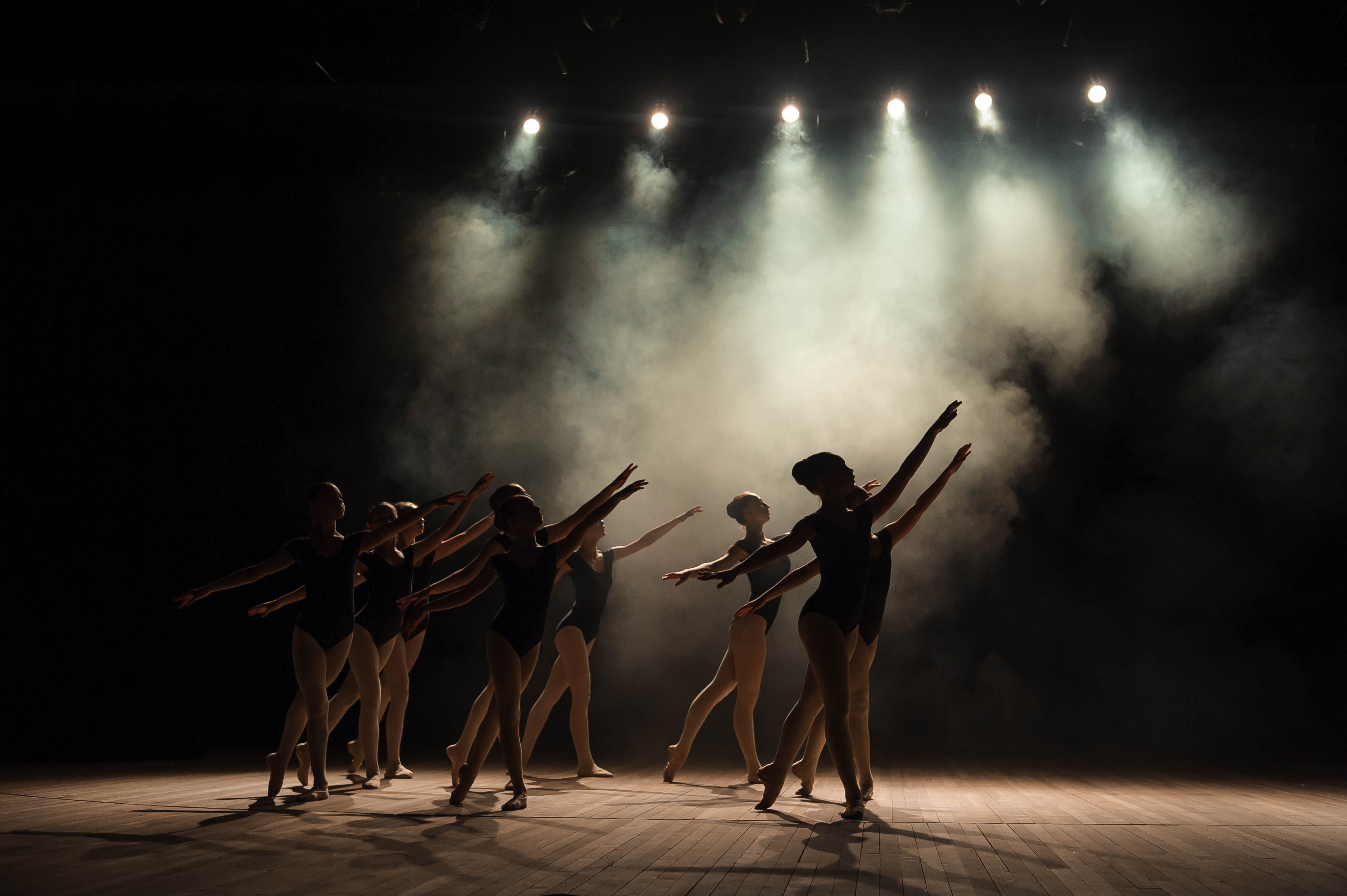 A group of dancers in black outfits on stage.