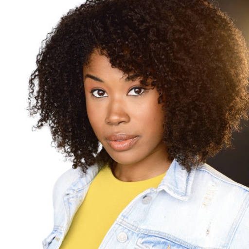 A woman with curly hair and yellow shirt.