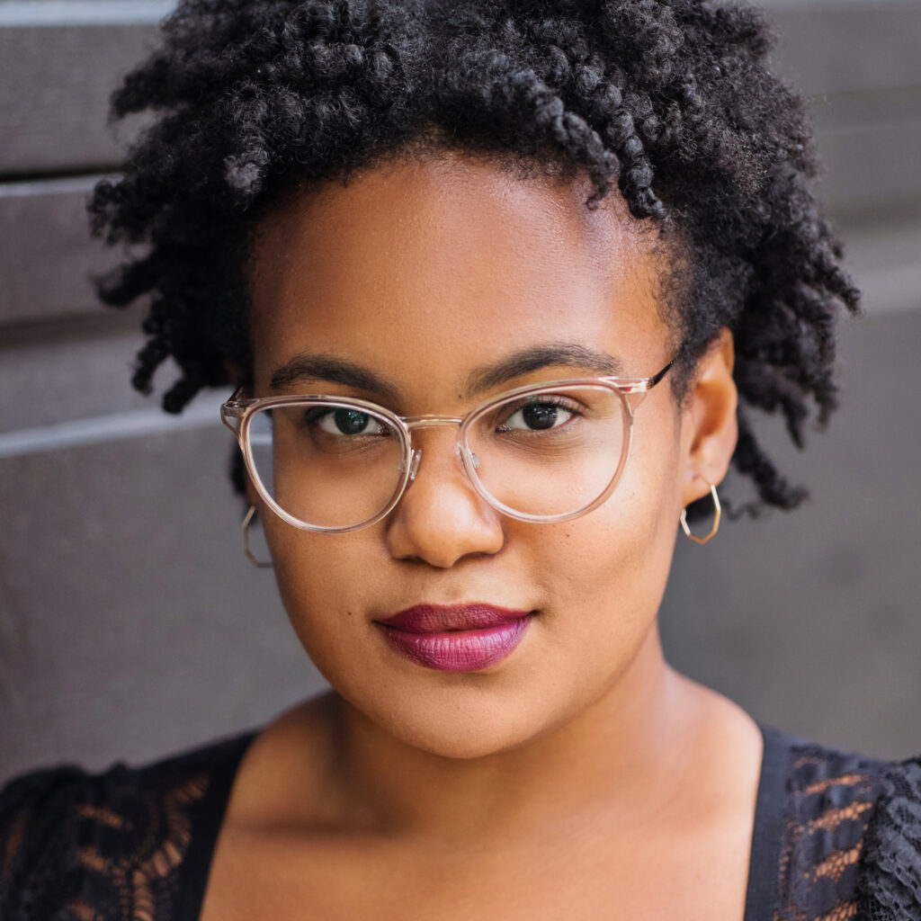 A woman with glasses and a black top