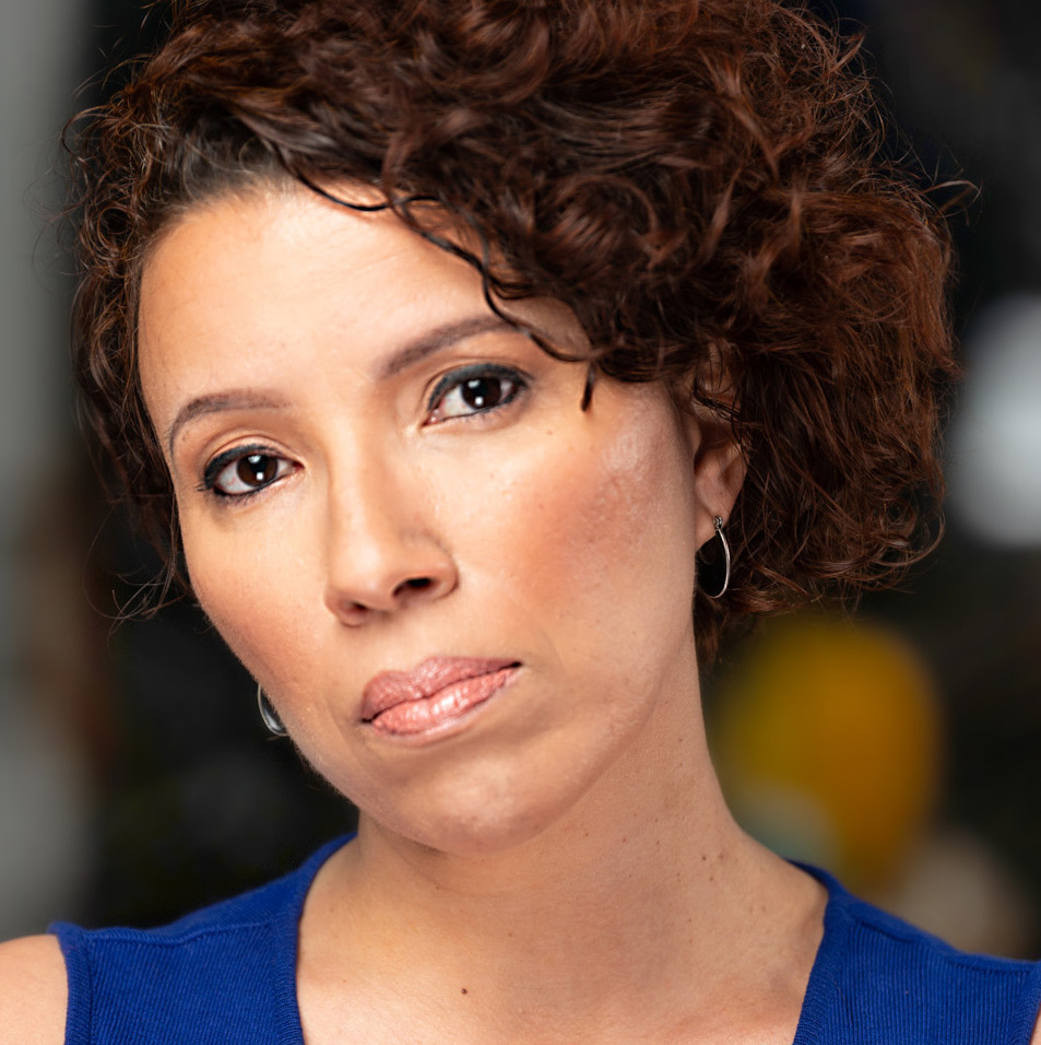 A woman with curly hair and blue shirt.