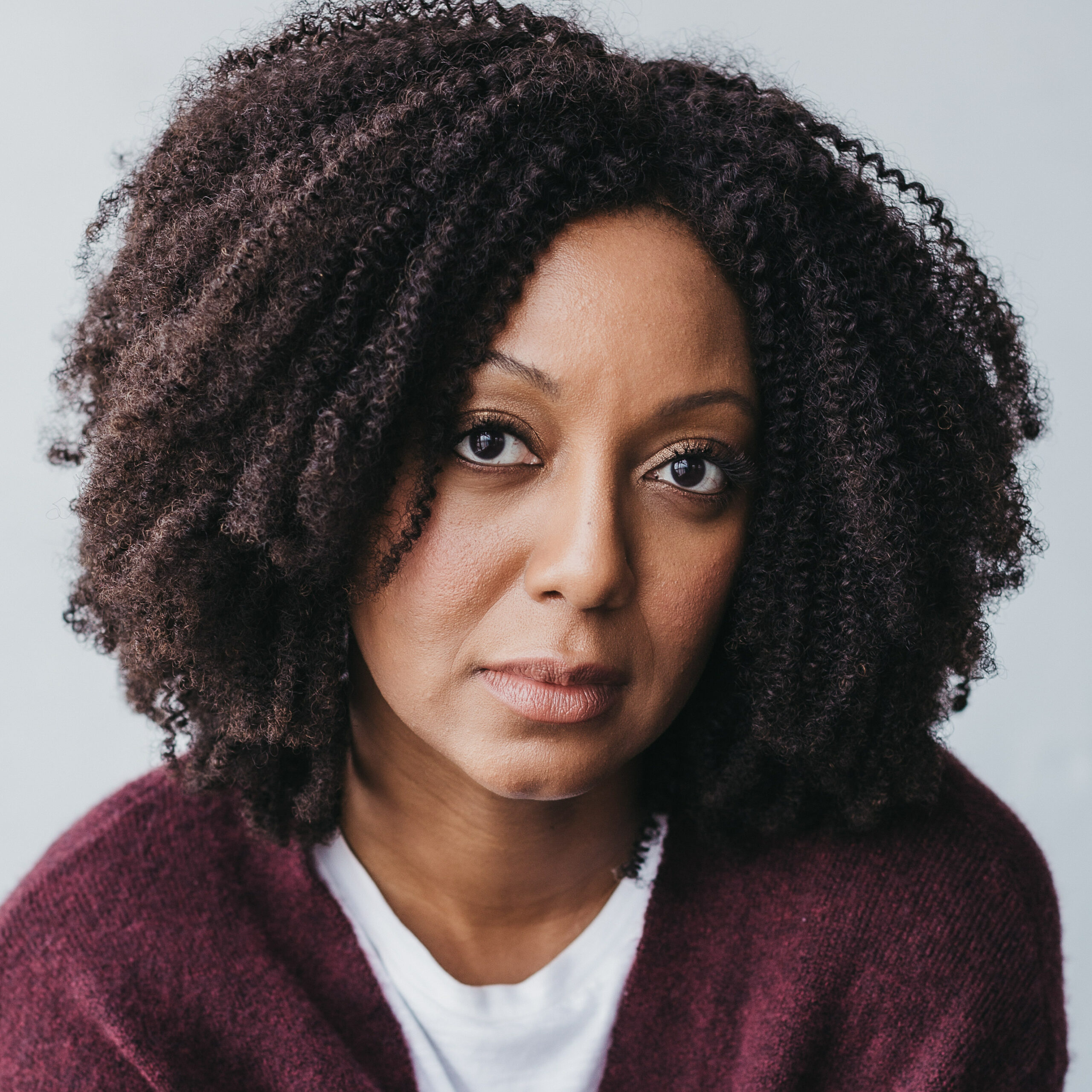 A woman with long hair and wearing a sweater.