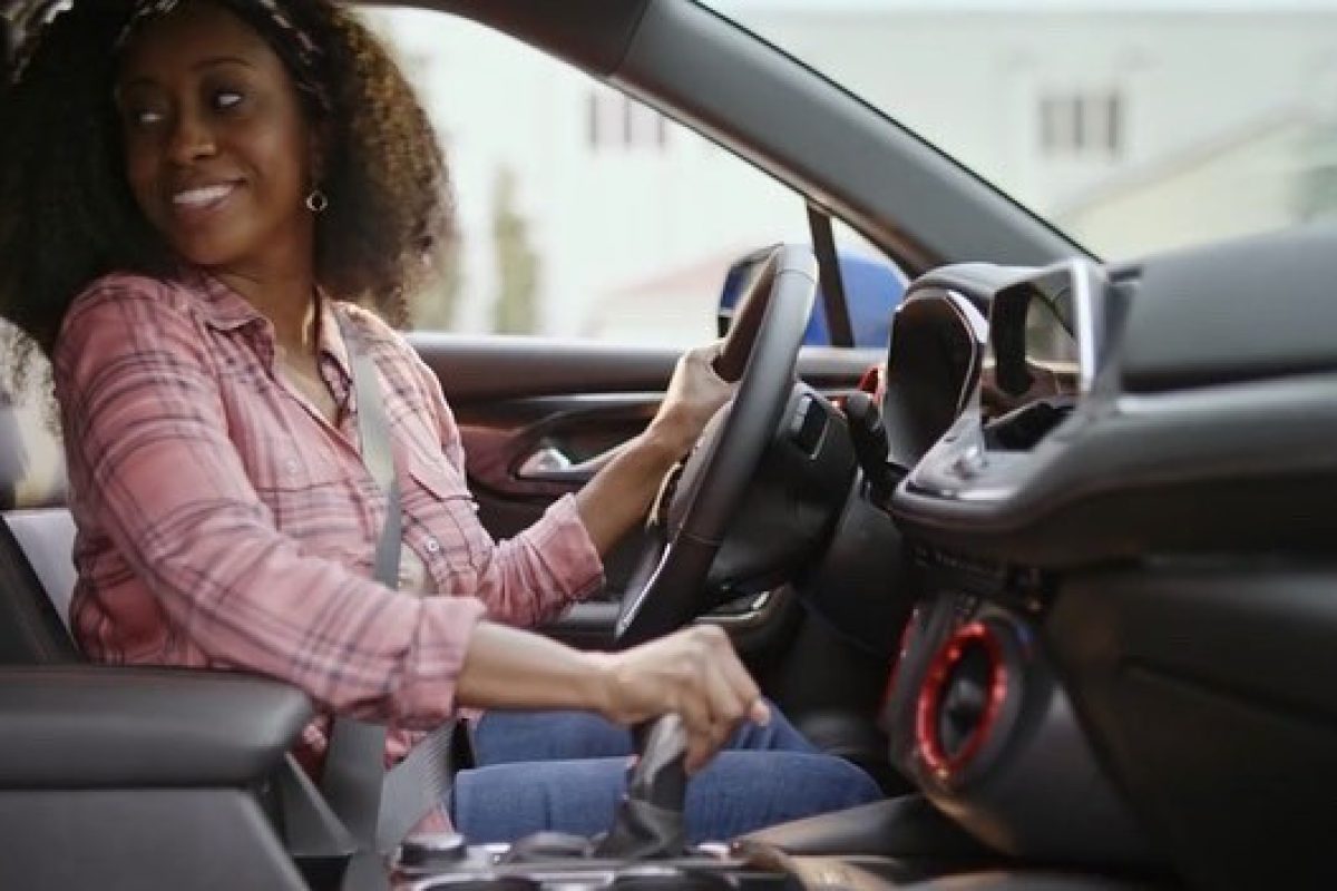 A woman sitting in the driver 's seat of her car.