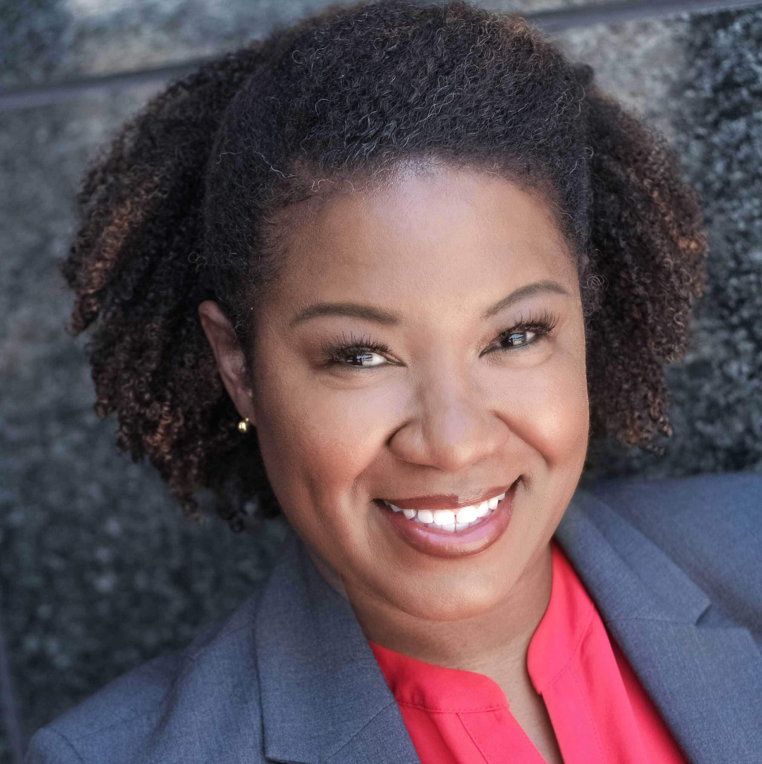 A woman with a red shirt and black jacket