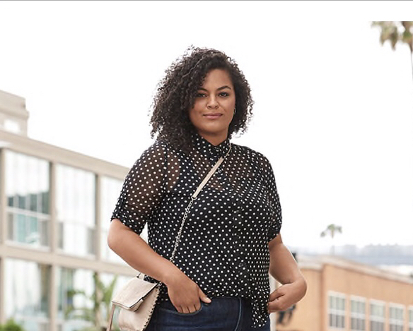 A woman standing outside with her hands in her pockets.