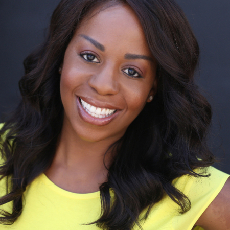 A woman with long black hair wearing a yellow shirt.