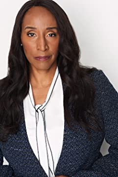 A woman with long black hair wearing a white shirt and jacket.