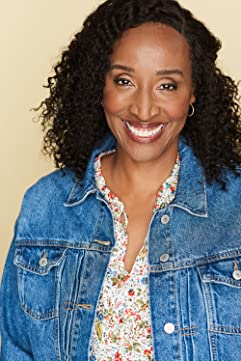 A woman with curly hair and a floral shirt.