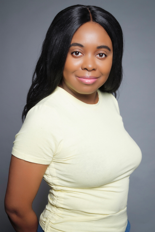 A woman in a yellow shirt posing for the camera.