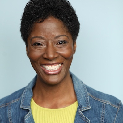 A woman with short hair wearing a jean jacket.